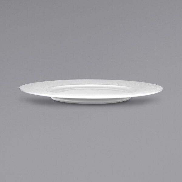 A white porcelain plate with a small rim on a gray background.