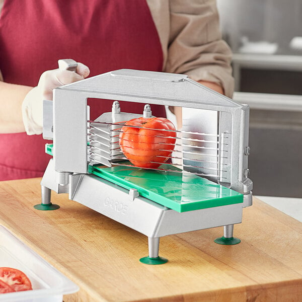 A woman using a Garde XL tomato slicer to slice a tomato.