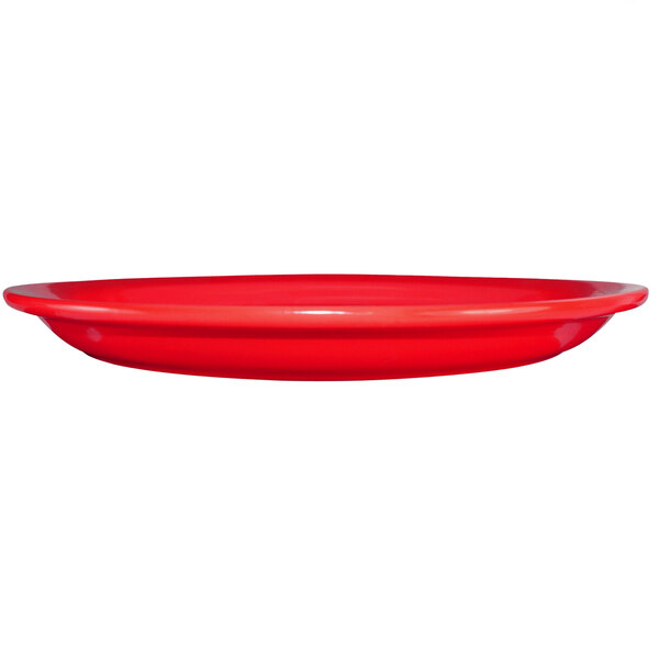 A crimson red stoneware platter on a white surface.