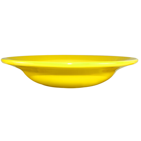 A close up of a yellow International Tableware stoneware deep rim soup bowl.