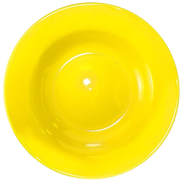 A yellow International Tableware stoneware deep rim soup bowl.