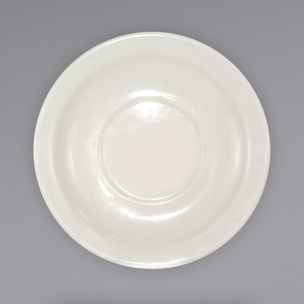 A close-up of an International Tableware Valencia ivory saucer with a narrow rim.
