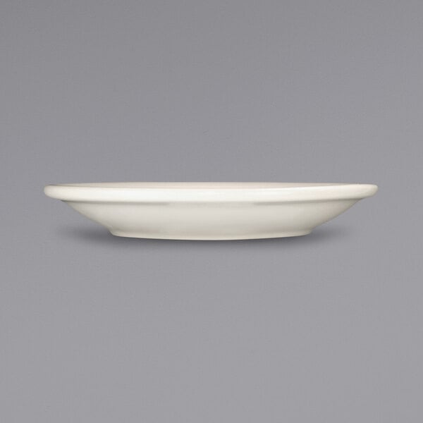 A white International Tableware Valencia narrow rim saucer.