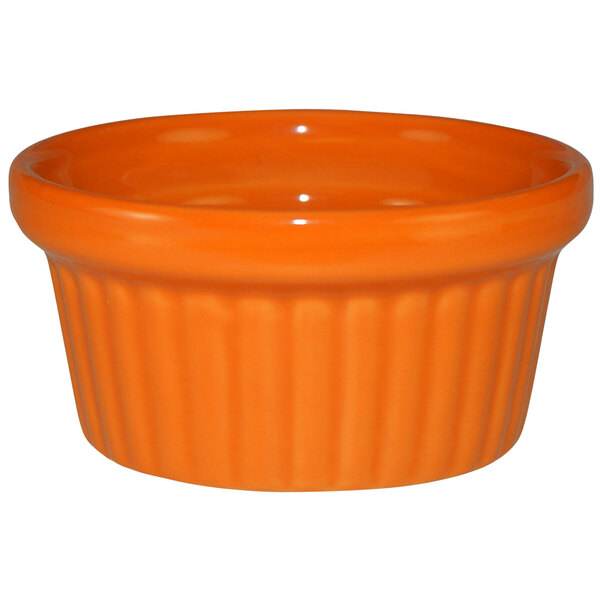 An orange stoneware fluted ramekin.