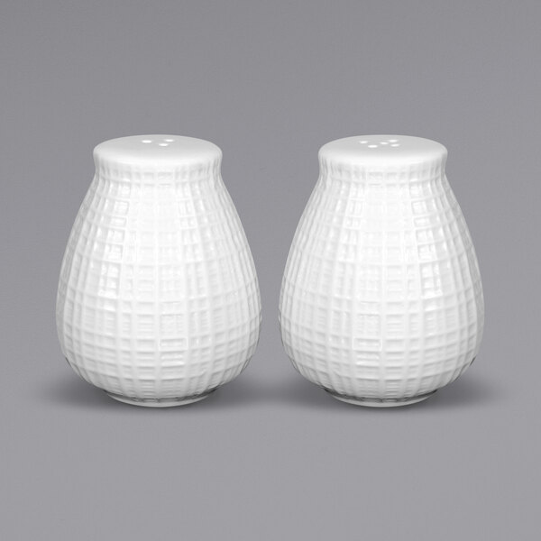 Two white International Tableware Dresden salt and pepper shakers.