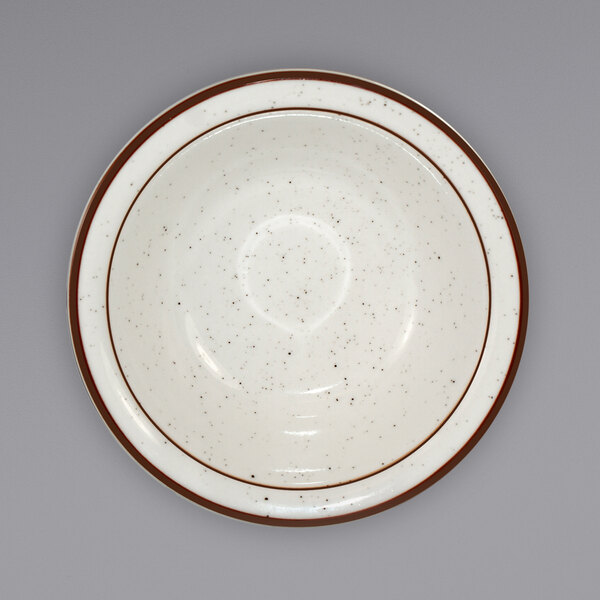 a white plate with brown speckled rim