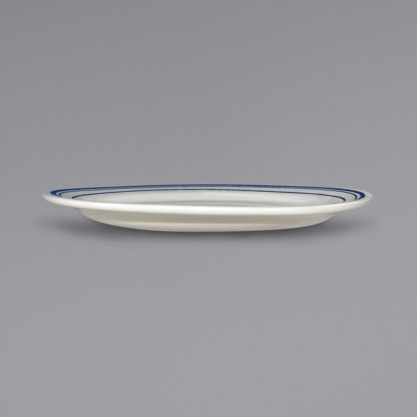 An International Tableware Catania ivory stoneware platter with blue bands on the rim.