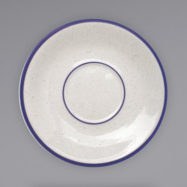 An International Tableware Danube ivory saucer with blue bands and speckles.