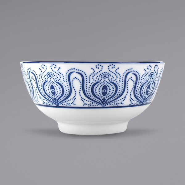 A close up of a white bowl with blue paisley designs.