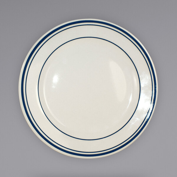 An ivory stoneware plate with blue bands on it.