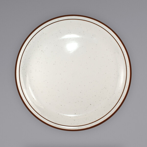 An International Tableware ivory stoneware plate with a brown speckled rim.