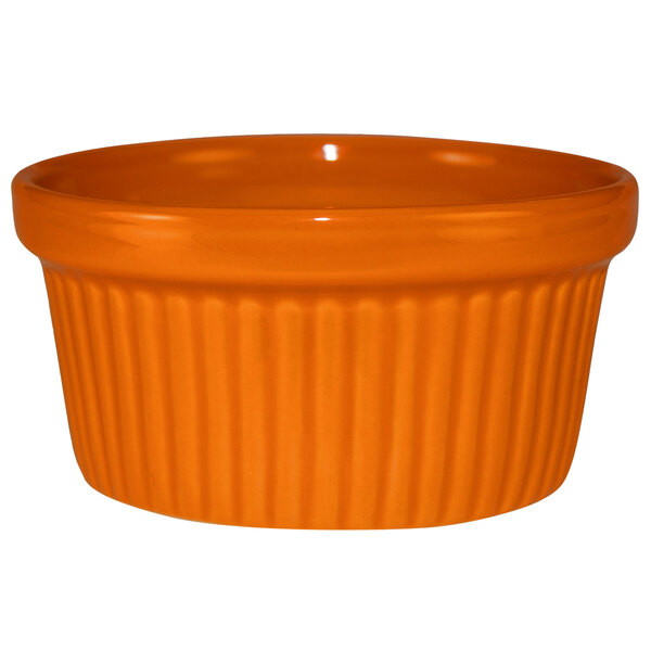 An orange stoneware fluted ramekin.