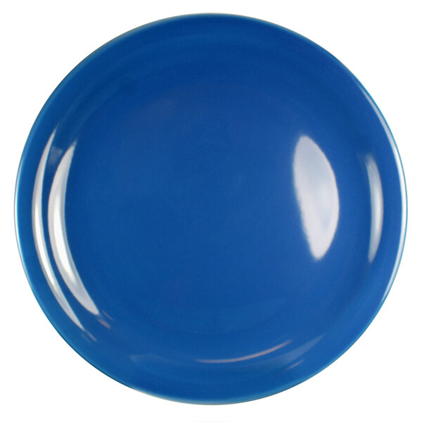 A close-up of a blue International Tableware stoneware plate with a narrow rim.