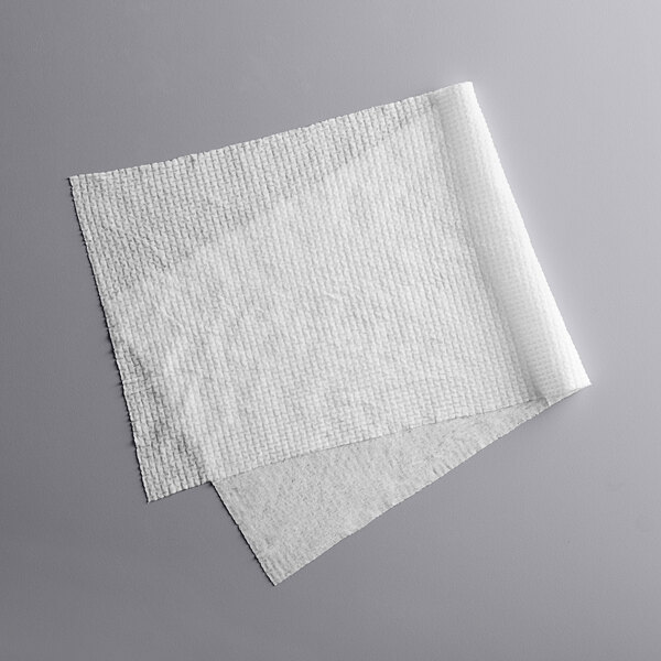 A white Mercer Culinary BLU™ compressed foodservice towel on a gray surface.