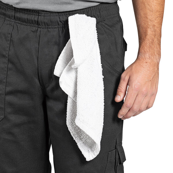 A man wearing Uncommon Chef black cargo pants with a towel on his waist.