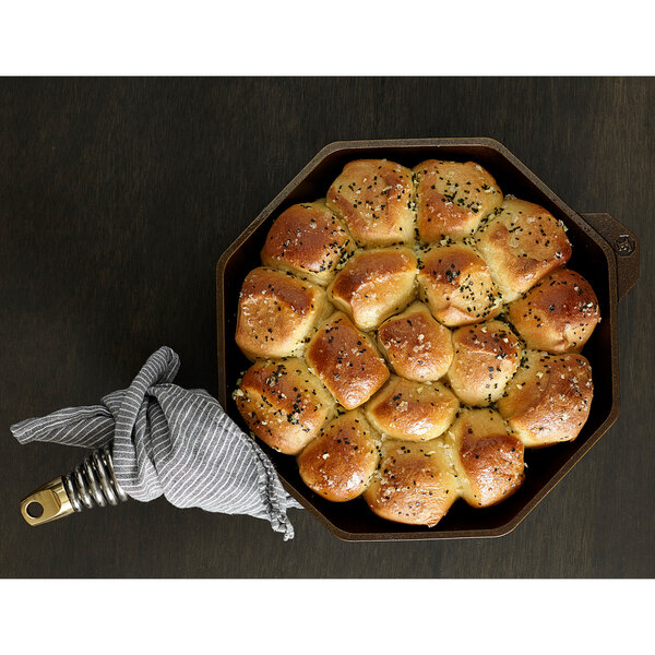 A Finex cast iron skillet with baked bread rolls in it.