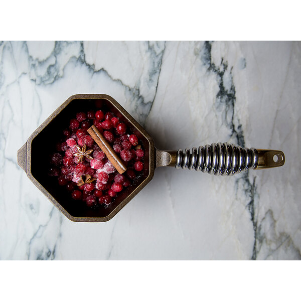 A FINEX cast iron sauce pan filled with cranberries and spices.