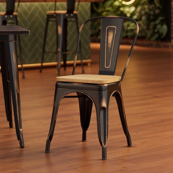 A Lancaster Table & Seating distressed copper metal chair with a natural wood seat at a wooden table in a restaurant.