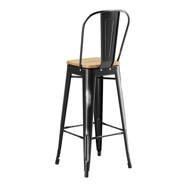 A Lancaster Table & Seating black metal barstool with a natural wood seat.