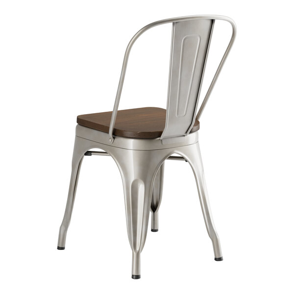 A Lancaster Table & Seating metal cafe chair with a walnut wood seat.