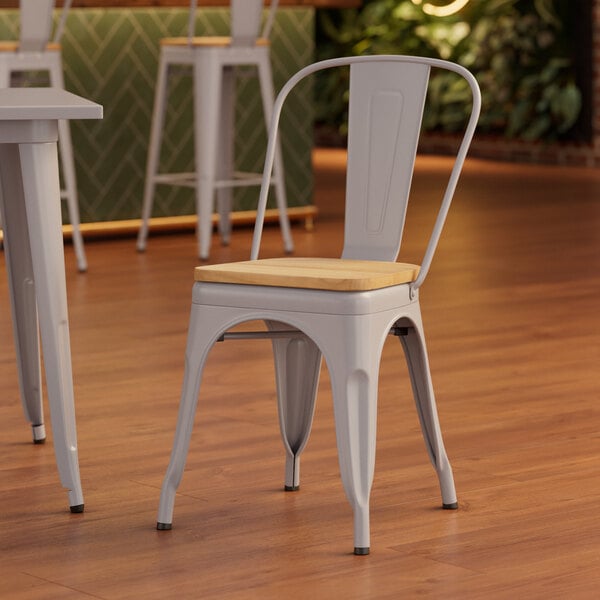 A Lancaster Table & Seating white chair with a natural wood seat and metal legs.