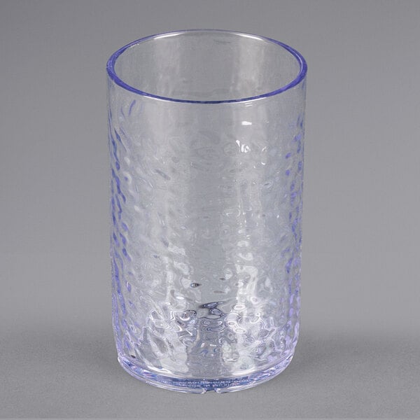 A Carlisle clear plastic tumbler with a blue rim.