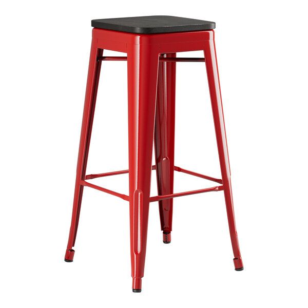 A Lancaster Table & Seating red metal barstool with a black seat.