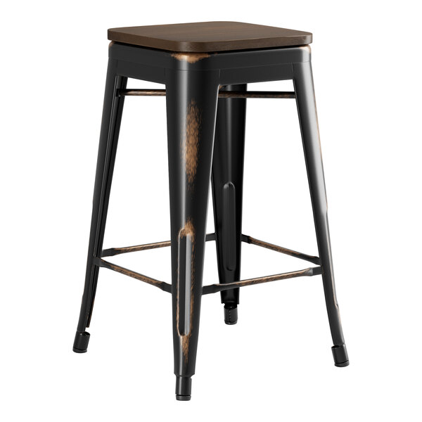 A black Lancaster Table & Seating backless counter height stool with a walnut seat.