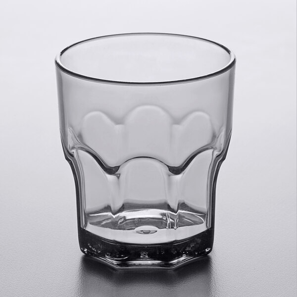 A Carlisle smoke SAN plastic tumbler with a curved edge.