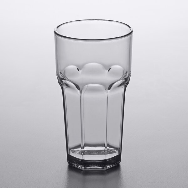 A smoke gray Carlisle plastic tumbler on a gray surface.