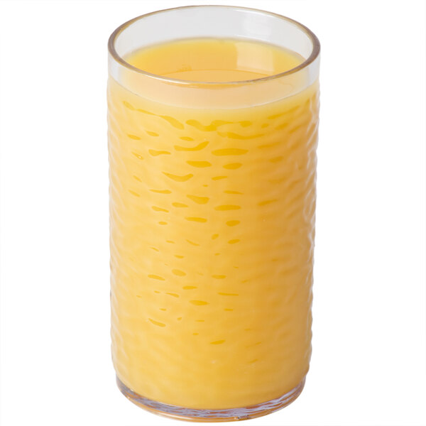 A Carlisle clear plastic tumbler filled with orange juice.