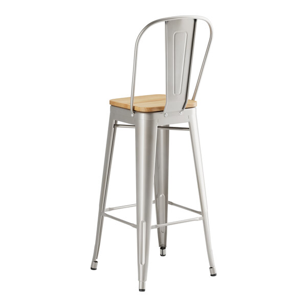 A Lancaster Table & Seating metal barstool with a natural wood seat.