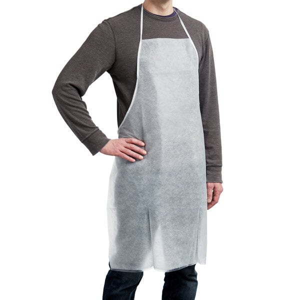 A man wearing a white AmerCare Royal PE laminated polypropylene apron.