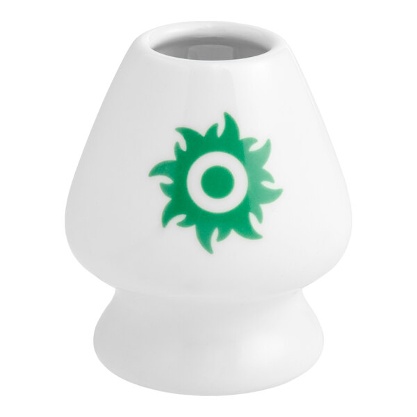 A white porcelain matcha whisk stand with a green circular design on the front.