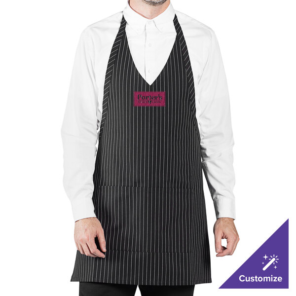 A black pinstripe V-neck tuxedo apron with an adjustable neck strap and two front pockets, worn over a white shirt.