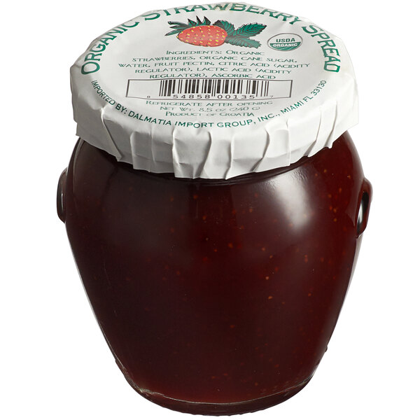 A close-up of a Dalmatia jar of strawberry spread with a white lid.