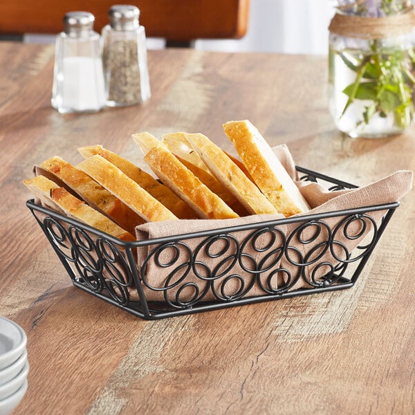 An American Metalcraft black metal rectangular basket with bread slices inside.