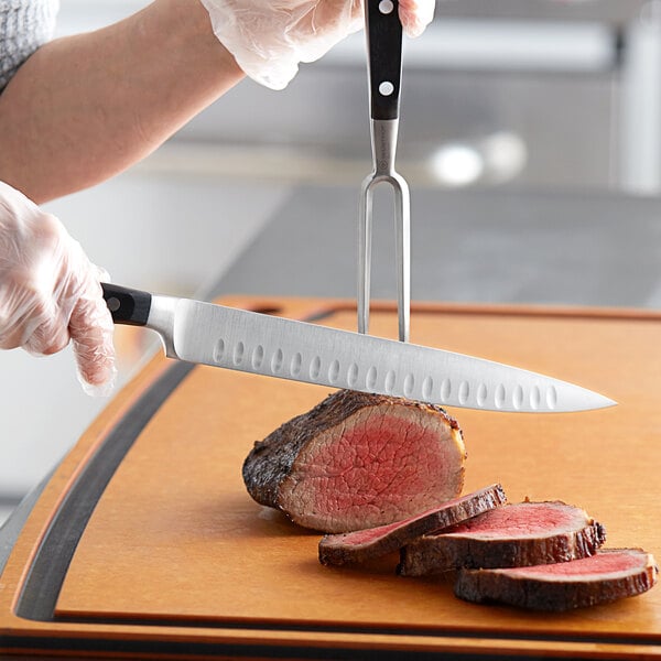 Chef using a carving knife to slice a roast