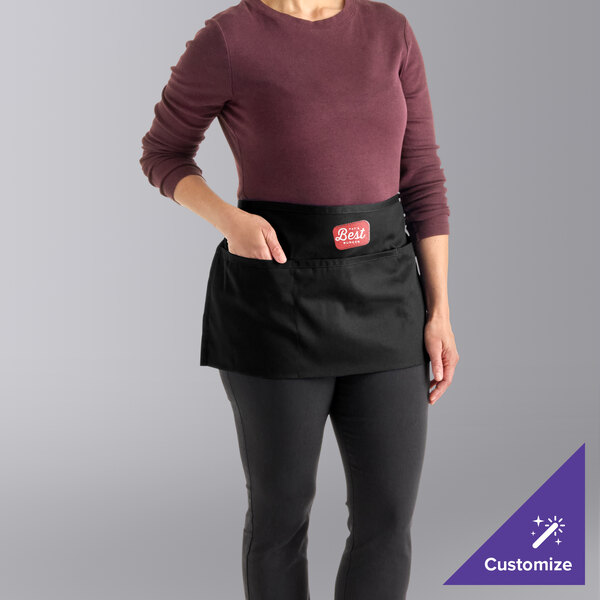 A black customizable waist apron with three pockets, worn by a person.
