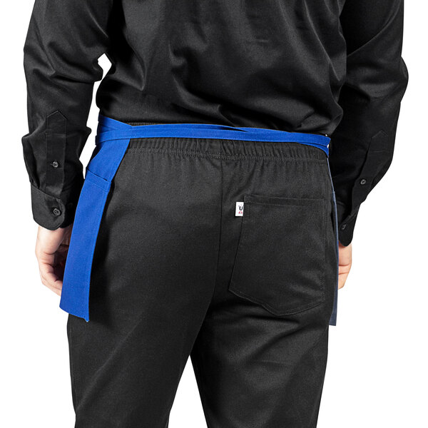 A person wearing a Royal Blue Uncommon Chef waist apron.