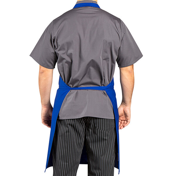 A man wearing a royal blue Uncommon Chef bib apron.