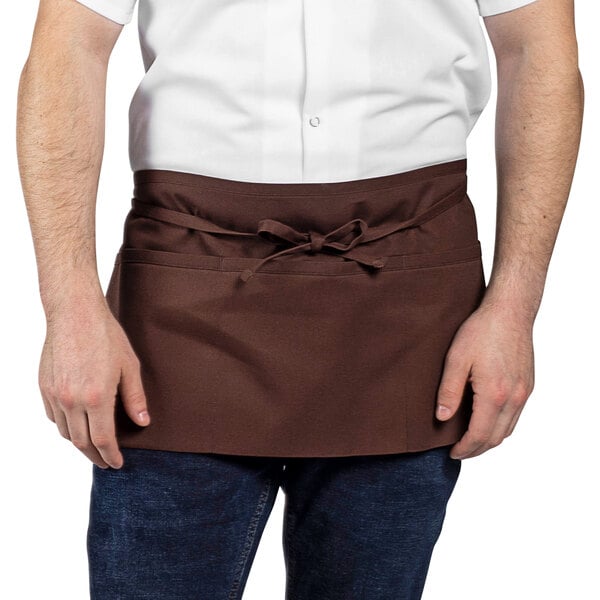 A man wearing a brown Uncommon Chef waist apron with 3 pockets.