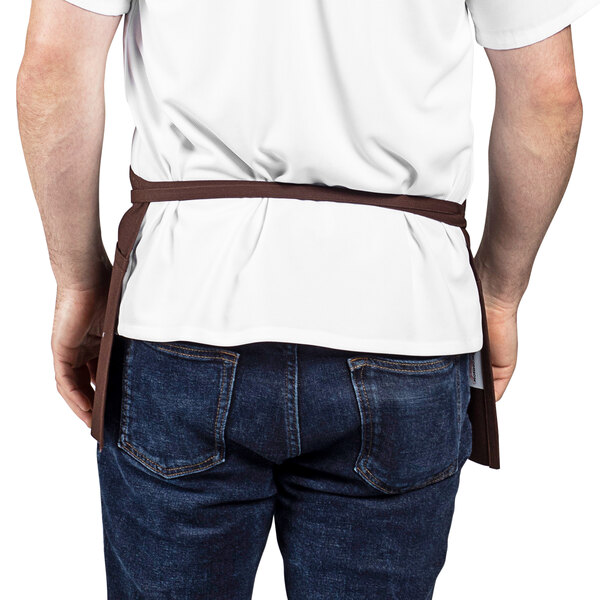 A man wearing a brown Uncommon Chef waist apron.