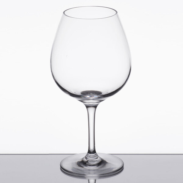 A Carlisle clear plastic wine glass on a reflective surface.