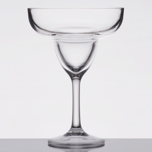 A clear Carlisle plastic margarita glass with a stem and a rim.