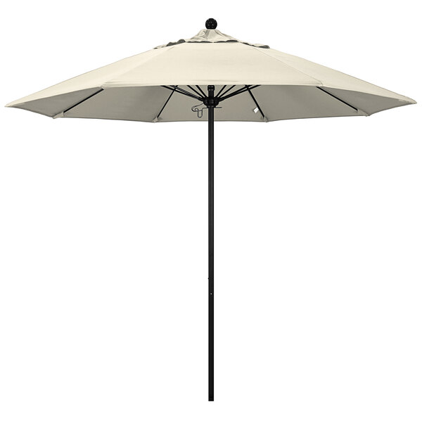 An antique beige California Umbrella with a black pole.