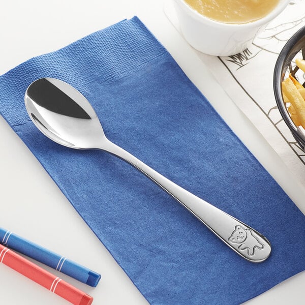 An Acopa medium weight stainless steel dinner spoon on a napkin.