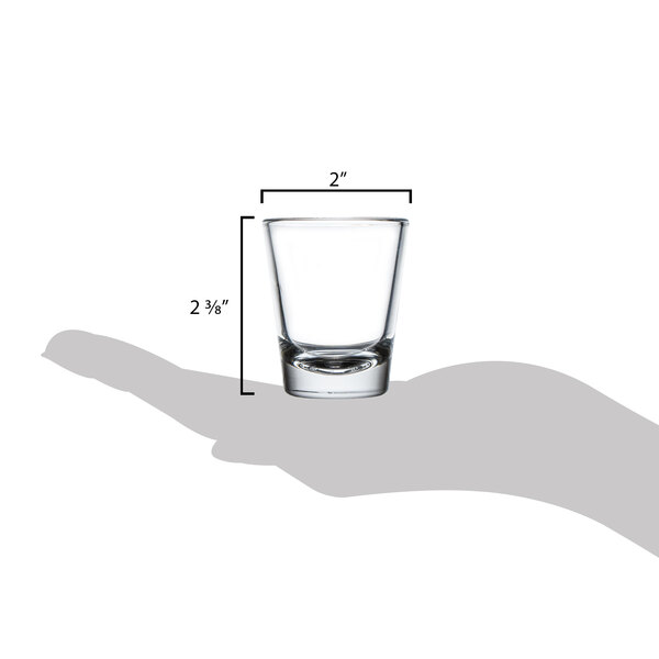 A hand holding a Libbey shot glass.