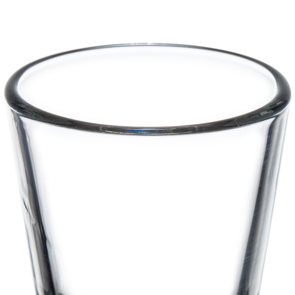A Libbey shot glass filled with clear liquid.