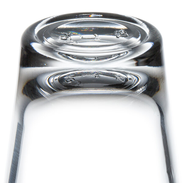 A close up of a Libbey shot glass on a table in a bar.